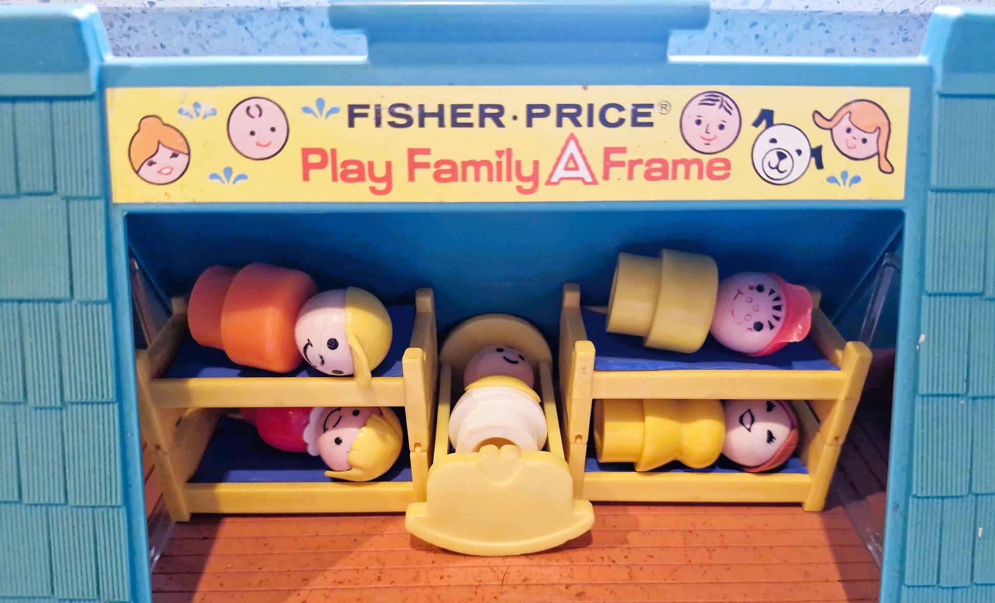 Fisher-Price toy set with characters and furniture in a play family frame.
